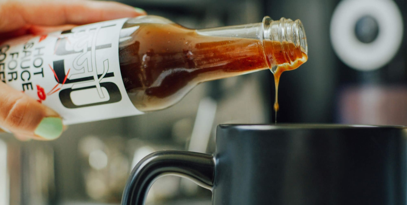 Sauce being poured into a mug of coffee